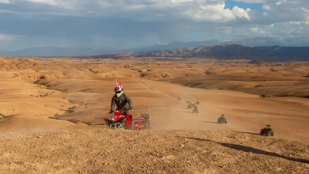 A convoy of quad bikes following a ridge track in the Agafay Desert